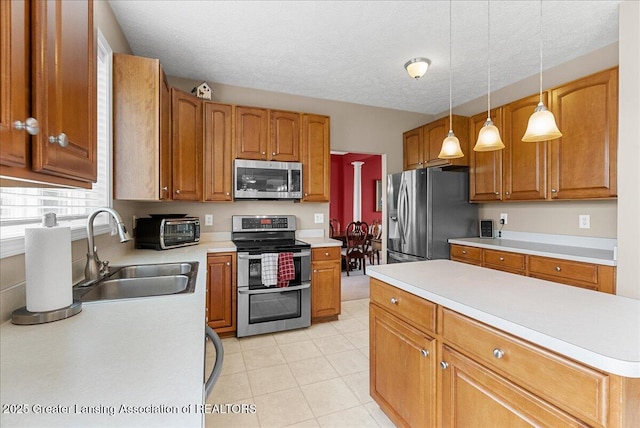 10889 Pointe W Blvd, Grand Ledge, MI 48837 - kitchen featuring stainless steel appliances, light countertops, hanging light fixtures, brown cabinets, and a textured ceiling