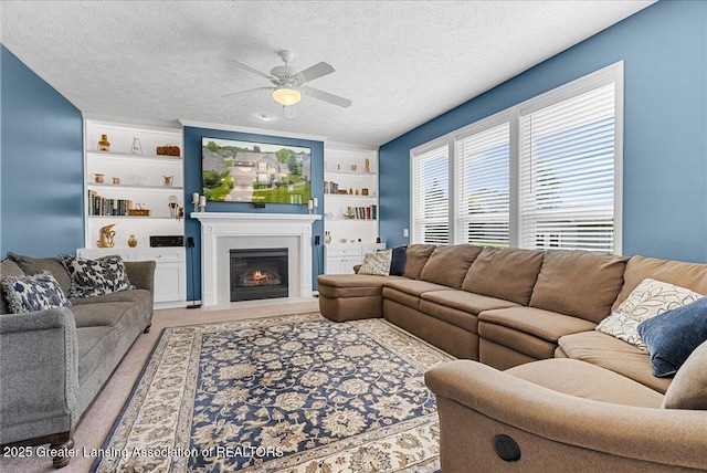 10889 Pointe W Blvd, Grand Ledge, MI 48837 - living room with a ceiling fan, light colored carpet, a fireplace with flush hearth, a textured ceiling, and built in shelves