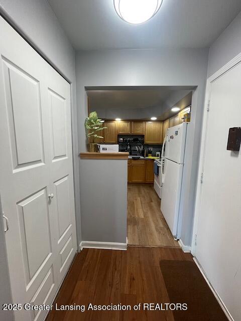5535 W St Joe Hwy Unit B12, Lansing, MI 48917 - kitchen with white appliances, wood finished floors, and brown cabinets