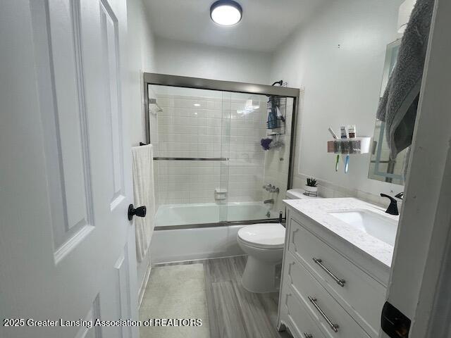 5535 W St Joe Hwy Unit B12, Lansing, MI 48917 - bathroom featuring vanity, shower / bath combination with glass door, and wood finished floors