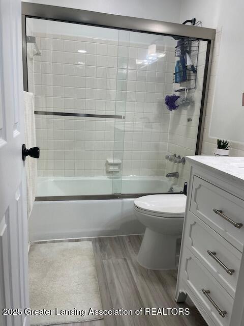 5535 W St Joe Hwy Unit B12, Lansing, MI 48917 - full bath with vanity, shower / bath combination with glass door, and wood finished floors
