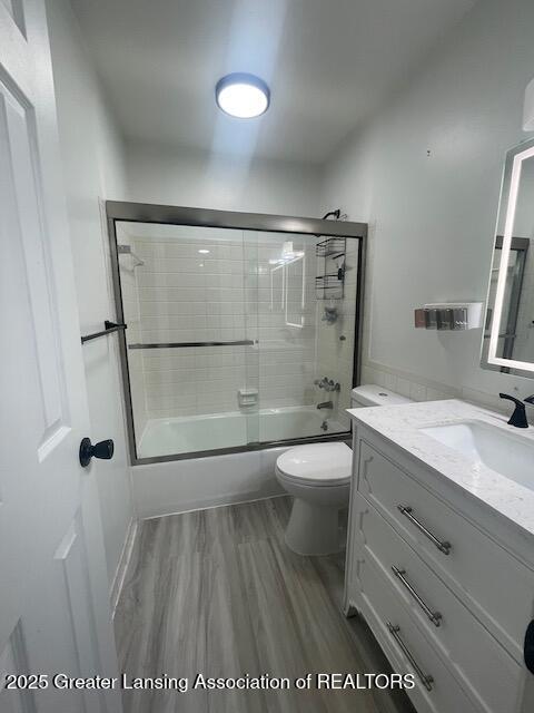 5535 W St Joe Hwy Unit B12, Lansing, MI 48917 - full bathroom with vanity, shower / bath combination with glass door, and wood finished floors