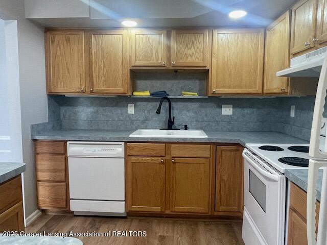 5535 W St Joe Hwy Unit B12, Lansing, MI 48917 - kitchen featuring white appliances, under cabinet range hood, dark wood-type flooring, and backsplash