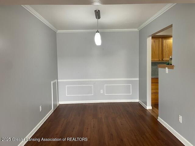 5535 W St Joe Hwy Unit B12, Lansing, MI 48917 - unfurnished dining area with dark wood finished floors, crown molding, and a wainscoted wall