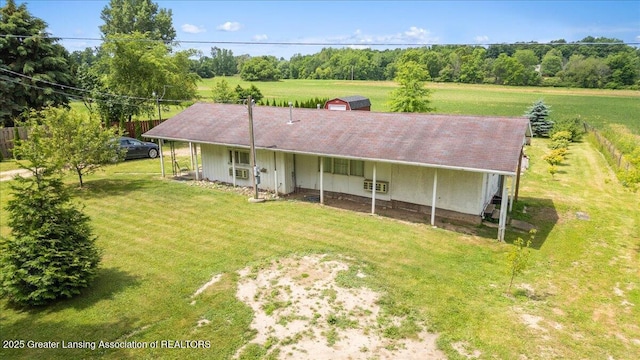 2243 Hubbard Rd, Charlotte, MI 48813 - back of house featuring a lawn and view of scattered trees