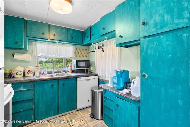 2243 Hubbard Rd, Charlotte, MI 48813 - kitchen featuring white dishwasher, black microwave, dark countertops, stove, and light flooring