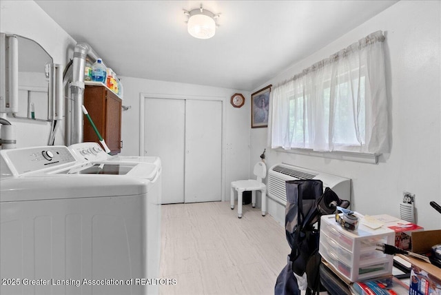2243 Hubbard Rd, Charlotte, MI 48813 - washroom featuring separate washer and dryer, light wood finished floors, and cabinet space