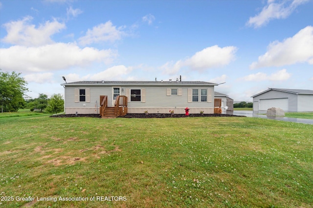 2744 Carlisle Hwy, Charlotte, MI 48813 - back of house featuring a yard and a garage