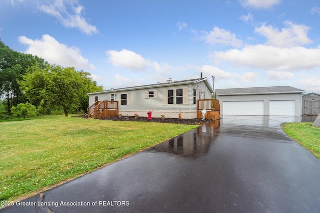 2744 Carlisle Hwy, Charlotte, MI 48813 - manufactured / mobile home featuring a detached garage, a front lawn, and a deck