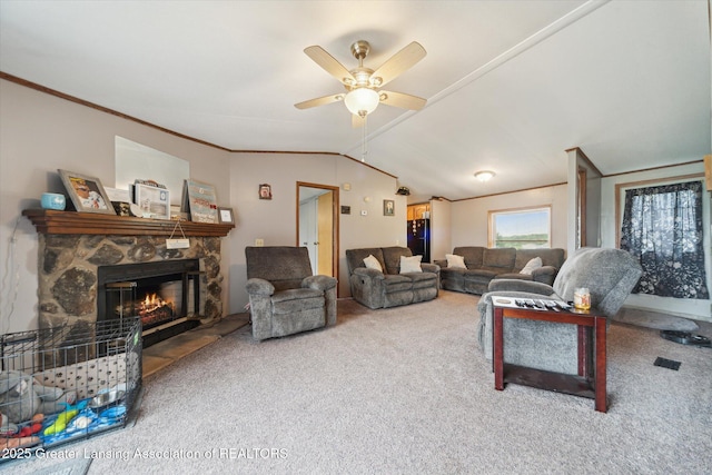 2744 Carlisle Hwy, Charlotte, MI 48813 - living room with carpet flooring, a ceiling fan, lofted ceiling, ornamental molding, and a stone fireplace