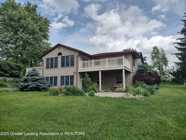 888 S Waverly Rd, Eaton Rapids, MI 48827 - rear view of property featuring a lawn, a patio area, and a wooden deck