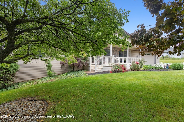888 S Waverly Rd, Eaton Rapids, MI 48827 - view of green lawn featuring covered porch and an attached garage
