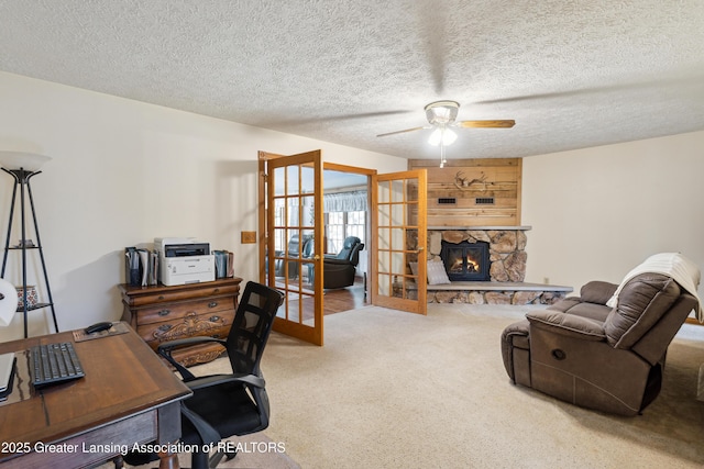 888 S Waverly Rd, Eaton Rapids, MI 48827 - carpeted home office featuring a ceiling fan, a stone fireplace, and a textured ceiling