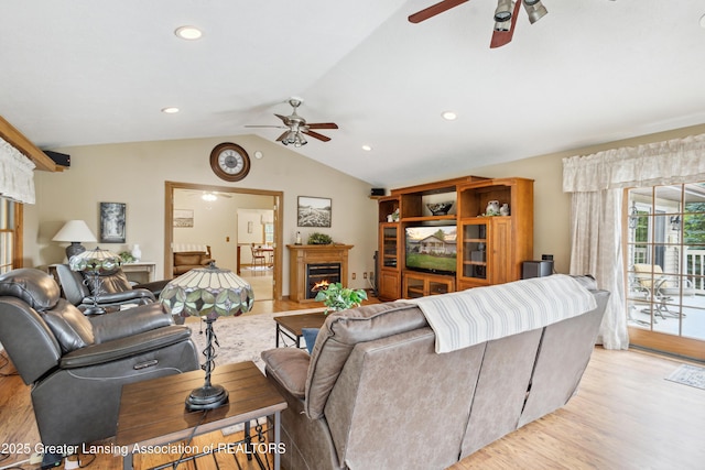 888 S Waverly Rd, Eaton Rapids, MI 48827 - living area with a ceiling fan, a warm lit fireplace, vaulted ceiling, light wood-type flooring, and recessed lighting