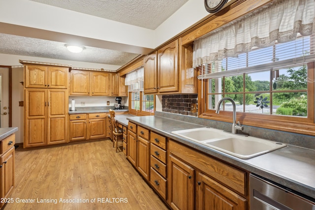 888 S Waverly Rd, Eaton Rapids, MI 48827 - kitchen featuring a textured ceiling, dishwasher, brown cabinets, light wood-style floors, and light countertops