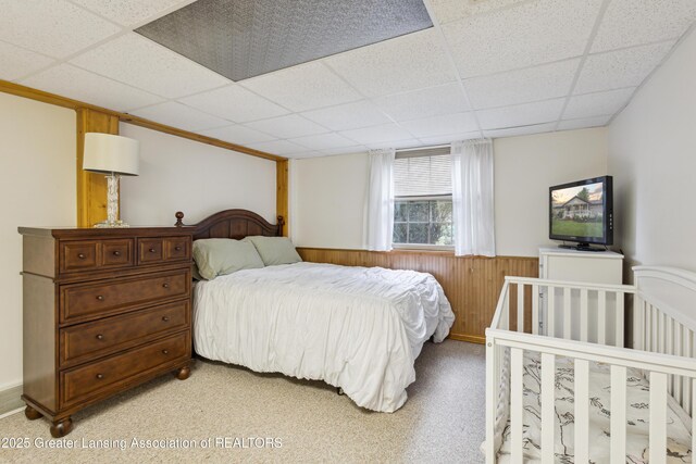 888 S Waverly Rd, Eaton Rapids, MI 48827 - bedroom featuring a paneled ceiling, a wainscoted wall, light carpet, and wooden walls