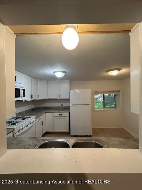 1318 Massachusetts Ave, Lansing, MI 48906 - kitchen with white appliances and white cabinets