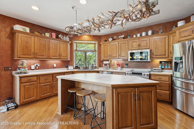 502 W Spring Meadows Ln, Dewitt, MI 48820 - kitchen with stainless steel appliances, a kitchen island, light wood-style floors, light countertops, and recessed lighting