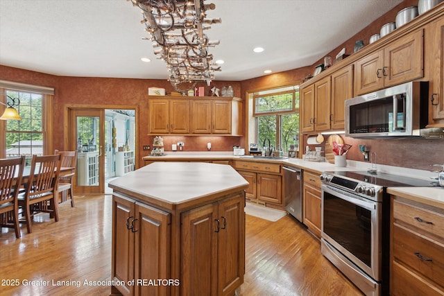 502 W Spring Meadows Ln, Dewitt, MI 48820 - kitchen featuring stainless steel appliances, brown cabinets, light countertops, light wood-style flooring, and recessed lighting