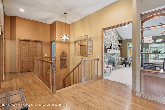 502 W Spring Meadows Ln, Dewitt, MI 48820 - foyer featuring wood finished floors, a fireplace, a chandelier, and a high ceiling