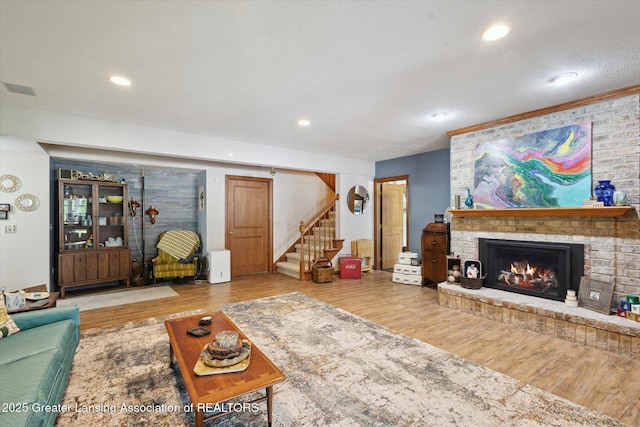 502 W Spring Meadows Ln, Dewitt, MI 48820 - living area with stairs, wood finished floors, a brick fireplace, and recessed lighting