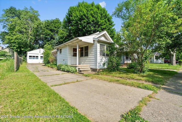 952 Leslie St, Lansing, MI 48912 - view of front of property featuring driveway, a front yard, an outdoor structure, a detached garage, and a porch