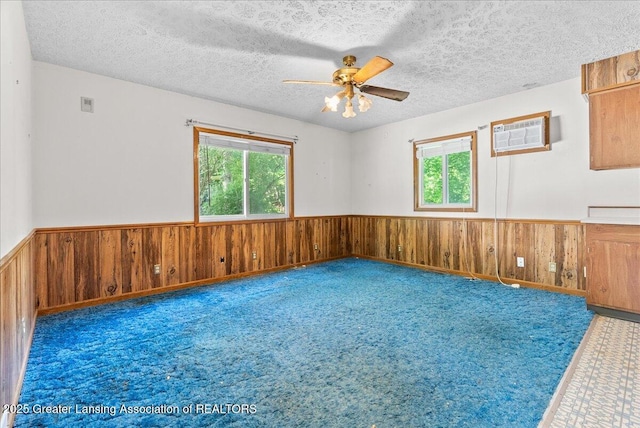952 Leslie St, Lansing, MI 48912 - spare room with healthy amount of natural light, a wainscoted wall, wooden walls, a ceiling fan, and carpet floors