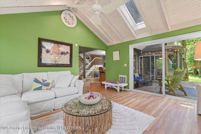 1122 Farwood Dr, East Lansing, MI 48823 - living area featuring a skylight, wood finished floors, ceiling fan, stairs, and high vaulted ceiling