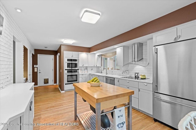 1122 Farwood Dr, East Lansing, MI 48823 - kitchen featuring stainless steel appliances, light countertops, decorative backsplash, and light wood-style floors