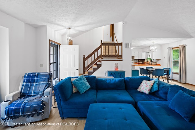2440 Sower Blvd, Okemos, MI 48864 - living room with wood finished floors, vaulted ceiling, stairway, a chandelier, and a textured ceiling