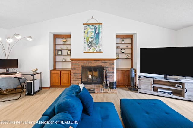 2440 Sower Blvd, Okemos, MI 48864 - living area featuring lofted ceiling, light wood finished floors, built in shelves, and a fireplace
