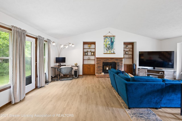 2440 Sower Blvd, Okemos, MI 48864 - living room featuring light wood finished floors, vaulted ceiling, a brick fireplace, and built in features