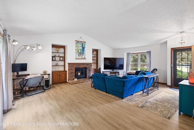 2440 Sower Blvd, Okemos, MI 48864 - living room with vaulted ceiling, wood finished floors, plenty of natural light, a brick fireplace, and built in features