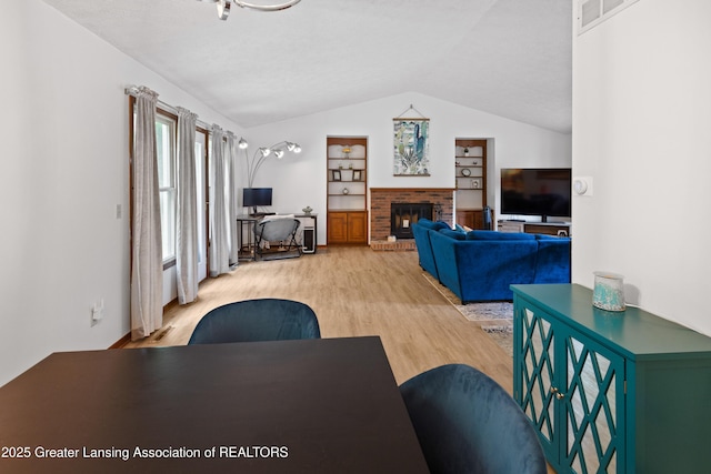 2440 Sower Blvd, Okemos, MI 48864 - living area featuring lofted ceiling, light wood-type flooring, a brick fireplace, built in features, and an office area