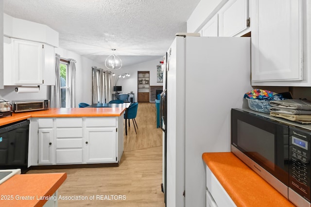 2440 Sower Blvd, Okemos, MI 48864 - kitchen featuring stainless steel microwave, freestanding refrigerator, light wood finished floors, a peninsula, and white cabinetry