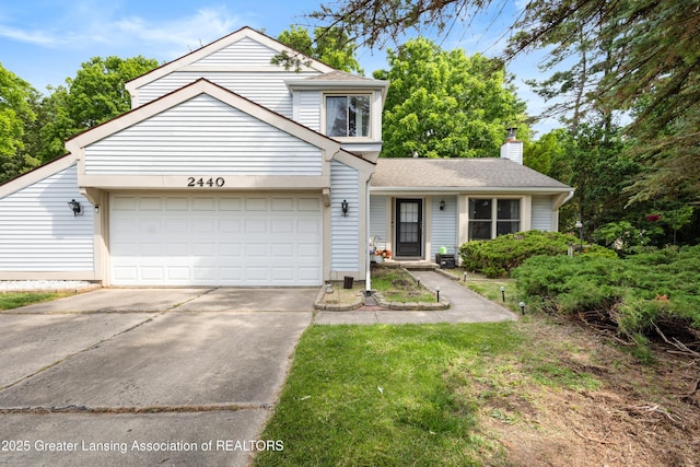 2440 Sower Blvd, Okemos, MI 48864 - traditional home featuring a garage, driveway, a chimney, and a shingled roof