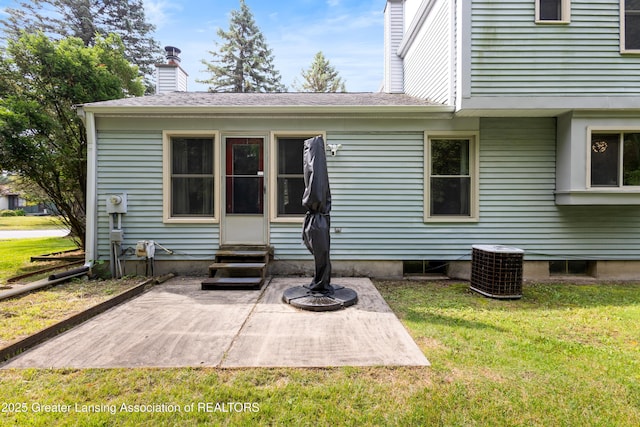 2440 Sower Blvd, Okemos, MI 48864 - rear view of property with entry steps, a lawn, a patio, a chimney, and a shingled roof