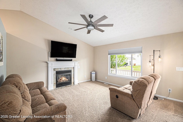 242 Coventry Ln, Mason, MI 48854 - carpeted living room with vaulted ceiling, ceiling fan, a fireplace, and a textured ceiling