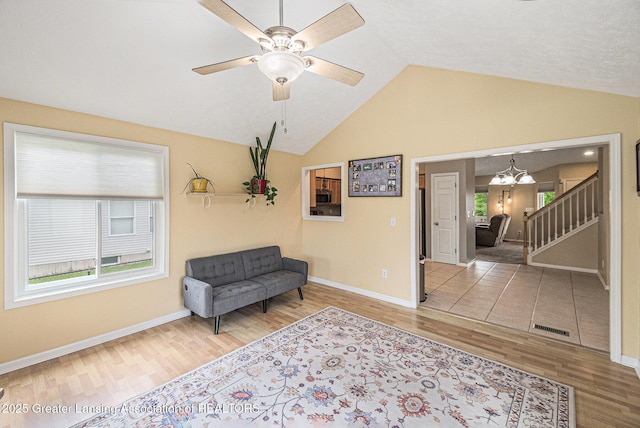 242 Coventry Ln, Mason, MI 48854 - sitting room with wood finished floors, a chandelier, stairway, vaulted ceiling, and a ceiling fan