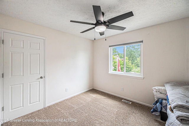 242 Coventry Ln, Mason, MI 48854 - unfurnished bedroom featuring light carpet, a ceiling fan, and a textured ceiling