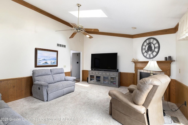 2352 Kings Cross N, East Lansing, MI 48823 - living room featuring carpet, a wainscoted wall, wooden walls, a skylight, and ceiling fan