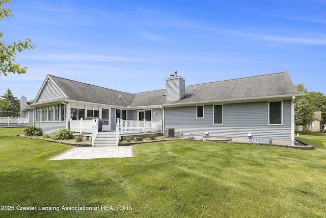 2352 Kings Cross N, East Lansing, MI 48823 - back of house featuring a patio area, a chimney, a sunroom, and a yard