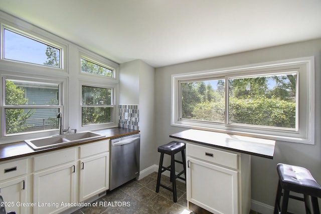 1321 Weber Dr, Lansing, MI 48912 - kitchen featuring dishwasher, healthy amount of natural light, and white cabinetry