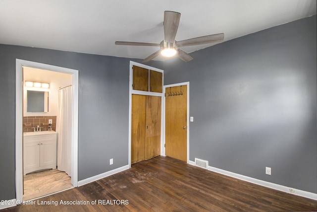 1321 Weber Dr, Lansing, MI 48912 - unfurnished bedroom featuring wood finished floors, ensuite bath, and a ceiling fan
