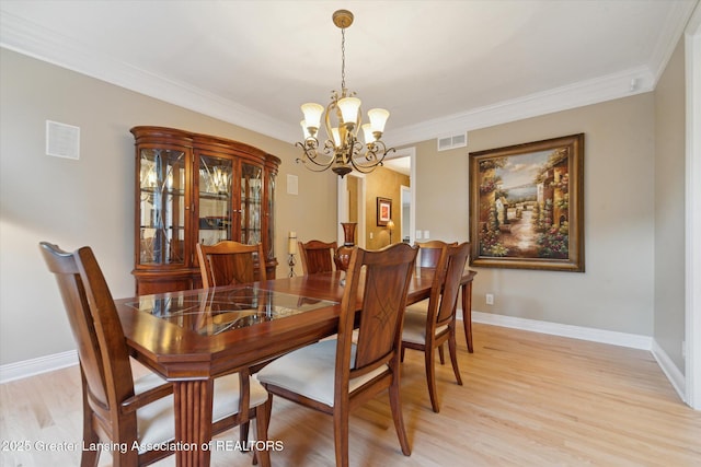 6378 E Island Lake Dr, East Lansing, MI 48823 - dining room with a chandelier, light wood-type flooring, and ornamental molding