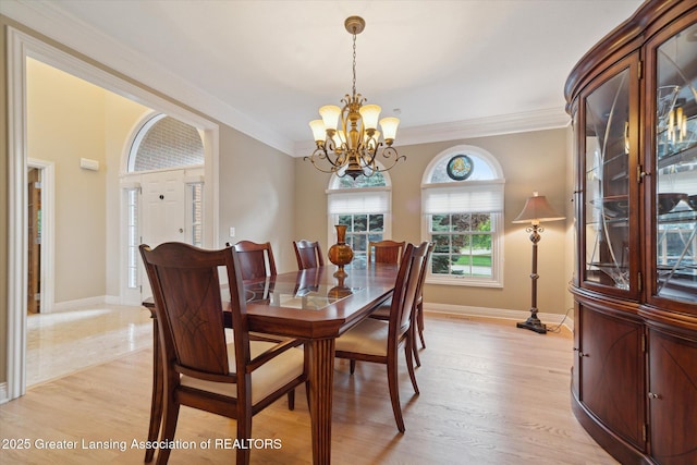 6378 E Island Lake Dr, East Lansing, MI 48823 - dining room featuring a chandelier, ornamental molding, and light wood-type flooring