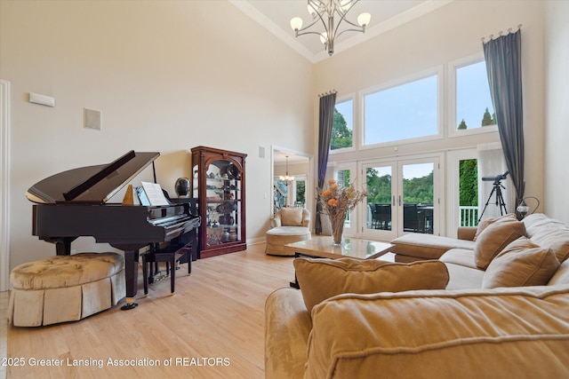 6378 E Island Lake Dr, East Lansing, MI 48823 - living area with a chandelier, high vaulted ceiling, ornamental molding, wood finished floors, and french doors