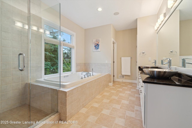 6378 E Island Lake Dr, East Lansing, MI 48823 - bathroom with double vanity, a garden tub, a stall shower, and recessed lighting
