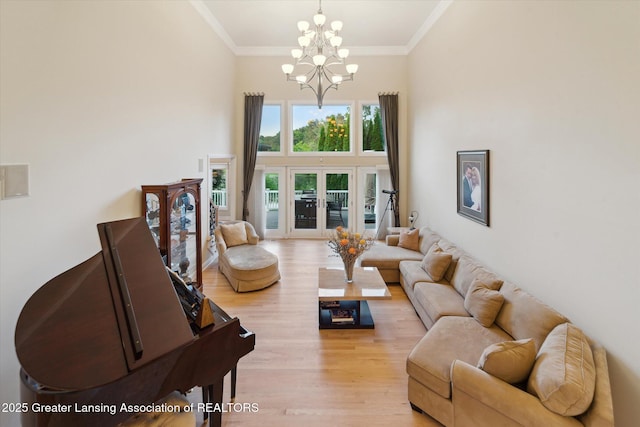 6378 E Island Lake Dr, East Lansing, MI 48823 - living area featuring light wood-type flooring, a chandelier, crown molding, and a towering ceiling