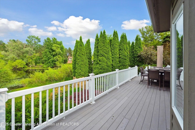 6378 E Island Lake Dr, East Lansing, MI 48823 - deck with outdoor dining space and a wooded view